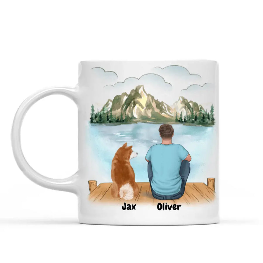 White ceramic coffee mug featuring a personalized illustration of a man and his dog sitting on a wooden dock overlooking a scenic mountain lake, with custom names "Jax" and "Oliver" printed below.